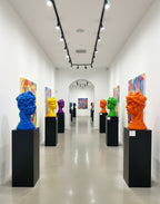 Art gallery with colorful sculptures on pedestals and abstract paintings on the walls. Sculptures by Mr. Clever Art.