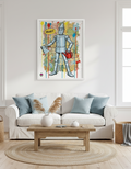 Framed artwork of a tin man in a living room with a sofa and coffee table.