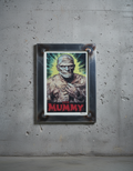 Framed poster of 'The Mummy' character on a gray wall.