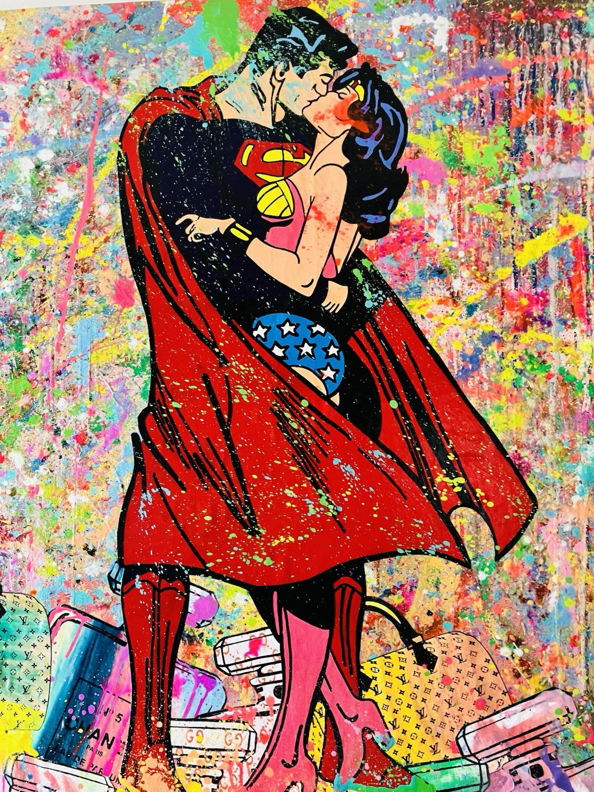 Superman and Wonder Woman embracing on a colorful abstract background
