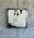 Framed artwork of a woman with long hair on a concrete wall