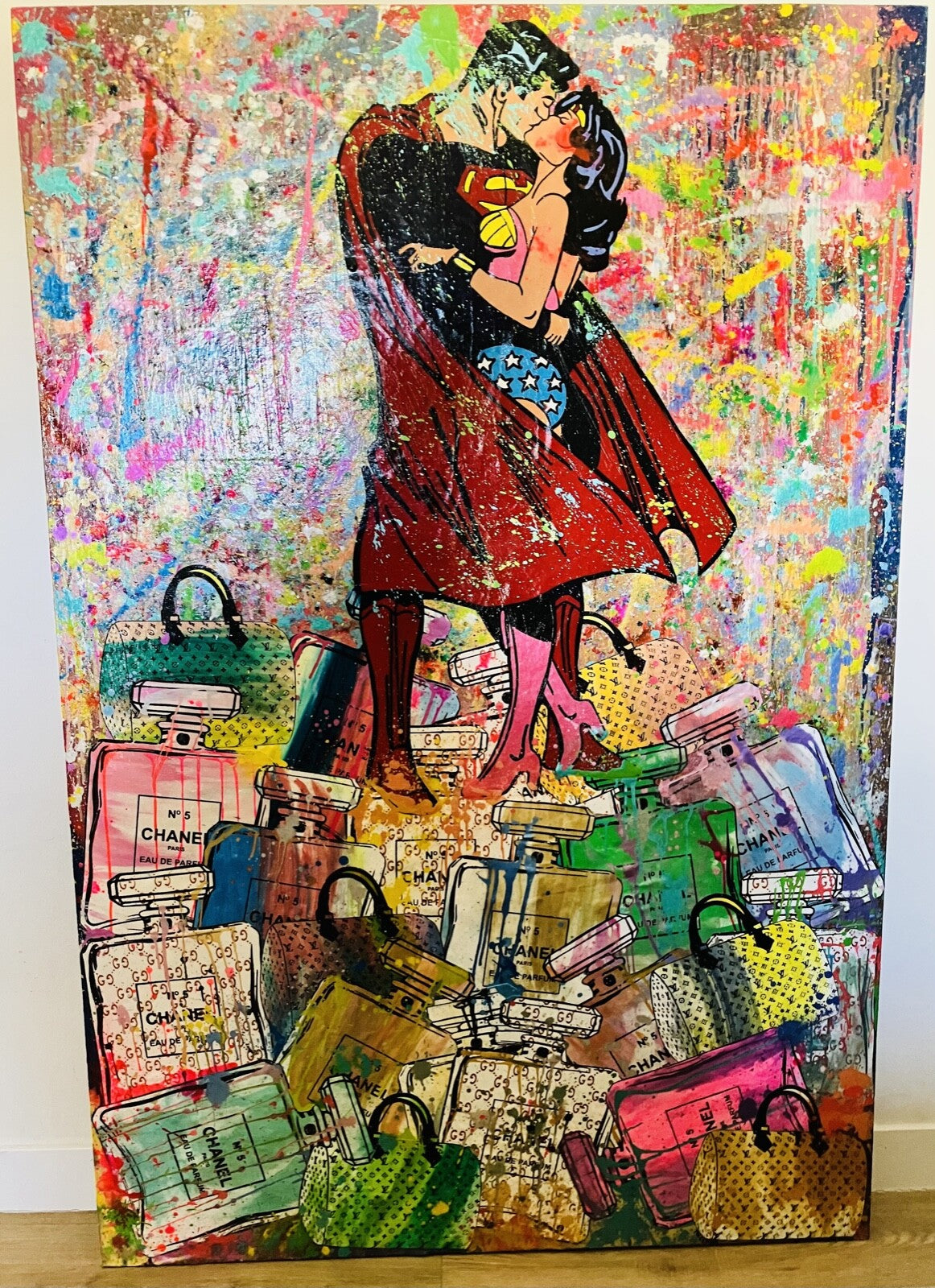 Collage art piece with a couple embracing, surrounded by colorful bags and books.