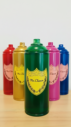 Set of colorful spray paint cans on a wooden surface with a white background. Sculptures by Mr. Clever Art.